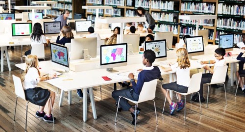 imagen de un aula digital con alumnos usando ordenadores.