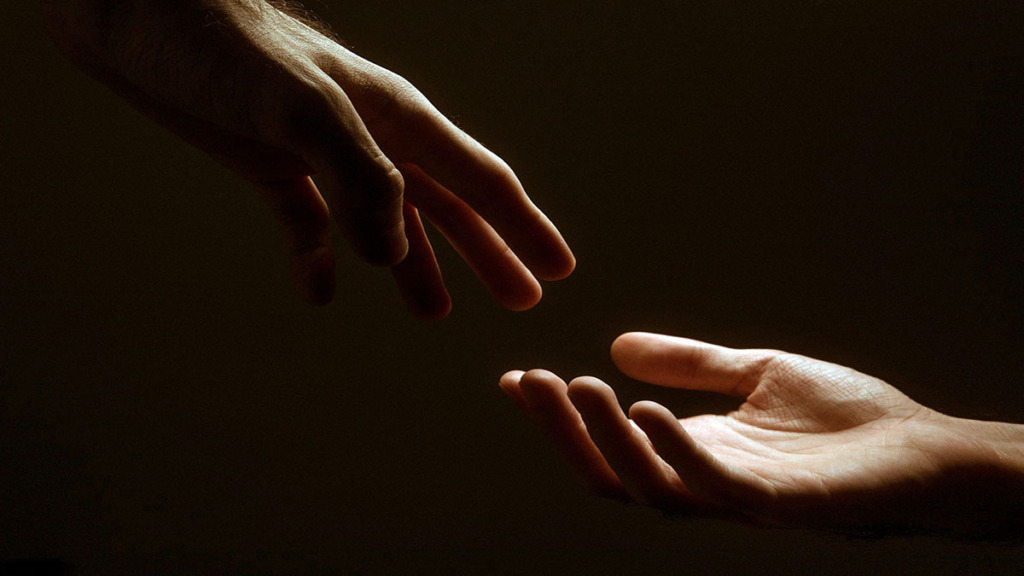 Imagen de dos manos de distintas personas rozándose simbolizando que aprenden a cuidar compasivamente.