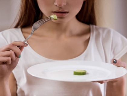 imagen de una joven con un plato de comida vacío.