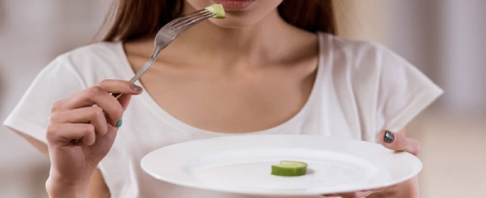 imagen de una joven con un plato de comida vacío.