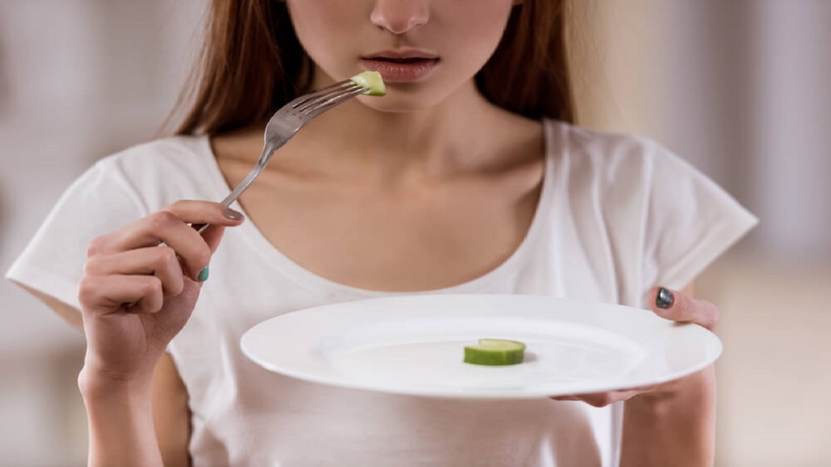 imagen de una joven con un plato de comida vacío.