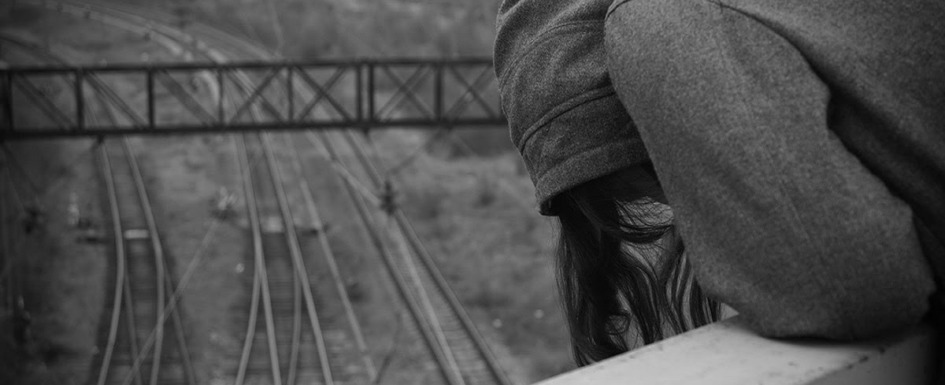prevenir el suicidio: imagen de una joven sobre las vías del tren