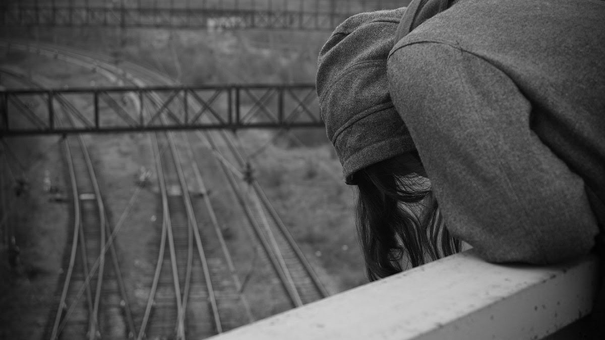 prevenir el suicidio: imagen de una joven sobre las vías del tren