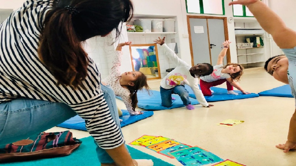 imagen de niños practicando yoga en un aula.