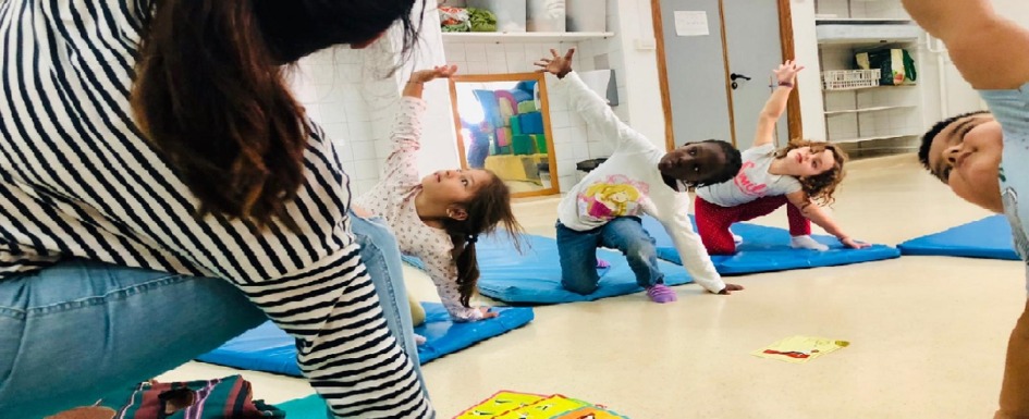 imagen de niños practicando yoga en un aula.