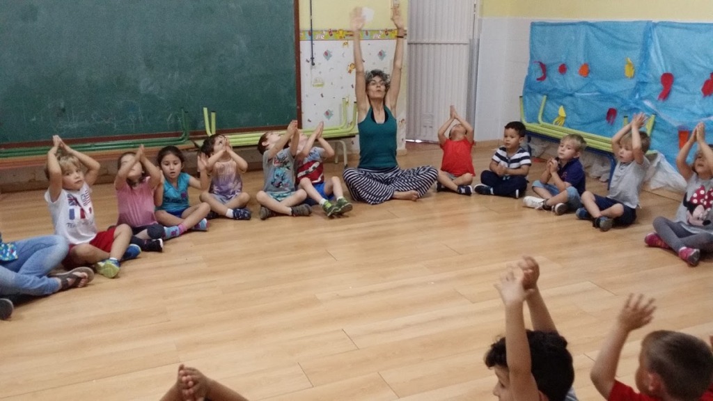 imagen de niños practicando yoga en un aula.