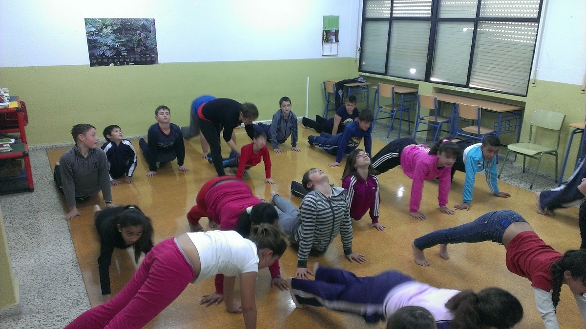 imagen de niños practicando yoga en un aula.