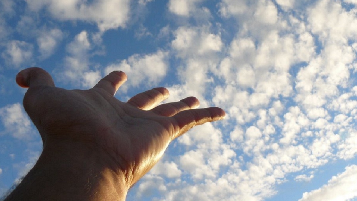 el arte de vivir, imagen de una mano tocando las nubes