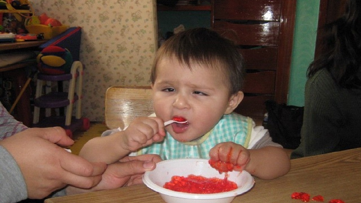imagen de niños con discapacidad visual, pequeño bebé aprendiendo a comer solo.