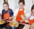 incorporar la cocina a las aulas: imagen de unos niños durante una clase de cocina
