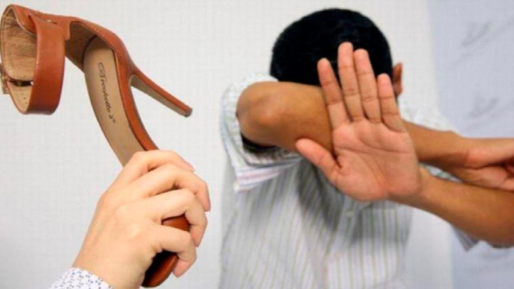 violencia doméstica: imagen de un hombre protegiéndose de un zapatazo de su mujer