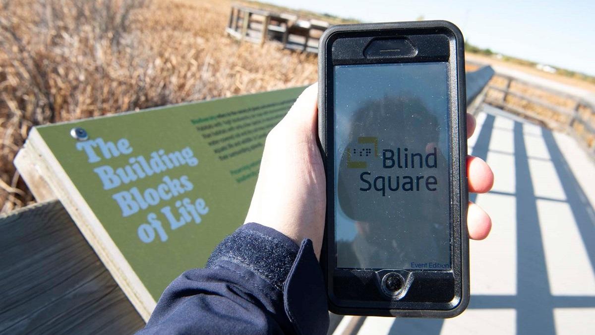 usuario de la aplicación blindsquare utilizándola en su teléfono móvil