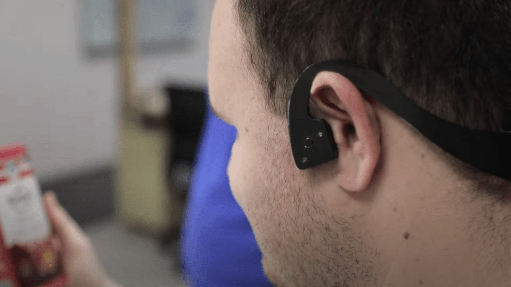 lateral de la cabeza de un usuario de AiSee mostrando uno de los terminales de conducción ósea