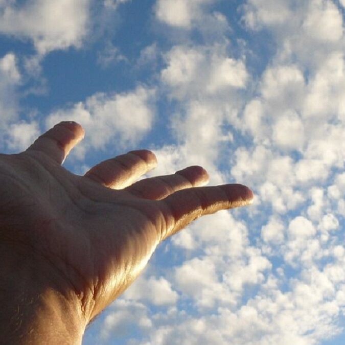el arte de vivir, imagen de una mano tocando las nubes