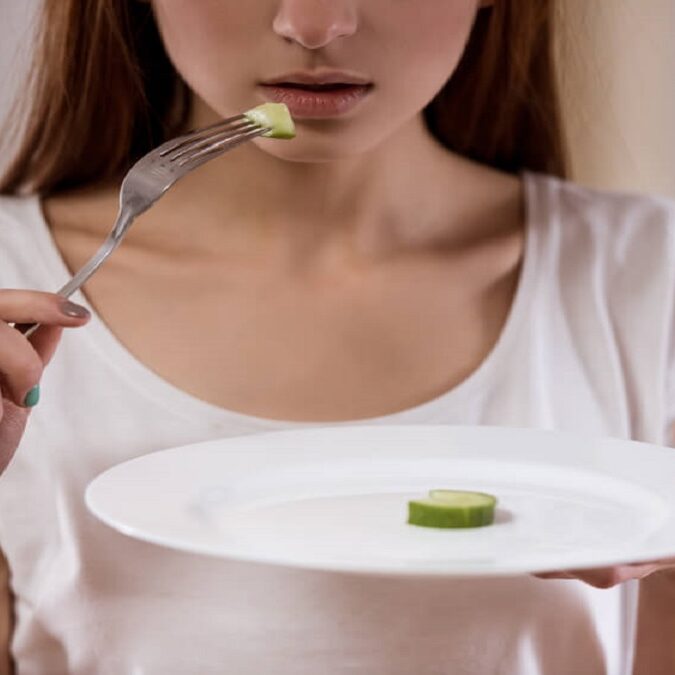 imagen de una joven con un plato de comida vacío.