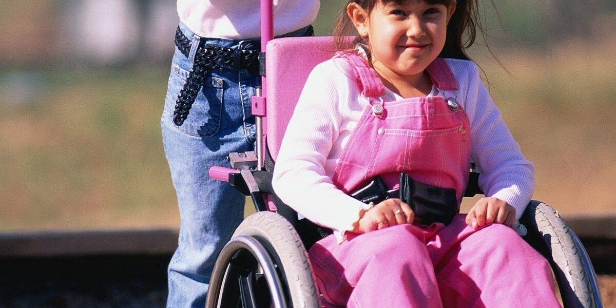 imagen de una niña con problemas de movilidad sentada en una silla de ruedas.